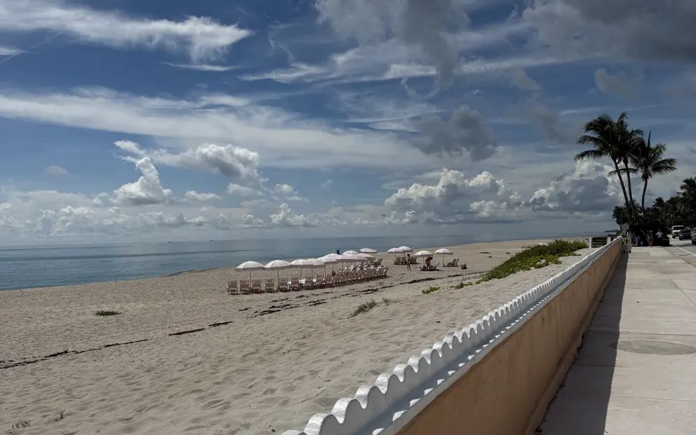 The scalloped seawall along the beach in Palm Beach, Florida, under a wide blue sky